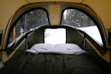 Cozy rooftop tent bedroom in RV rental, with mesh windows offering tranquil snowy forest views.