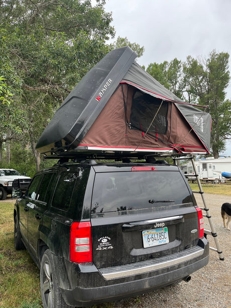  set up for camping. An exciting RV rental for outdoor adventures.|An RV rental SUV with a deployed rooftop tent. Inside