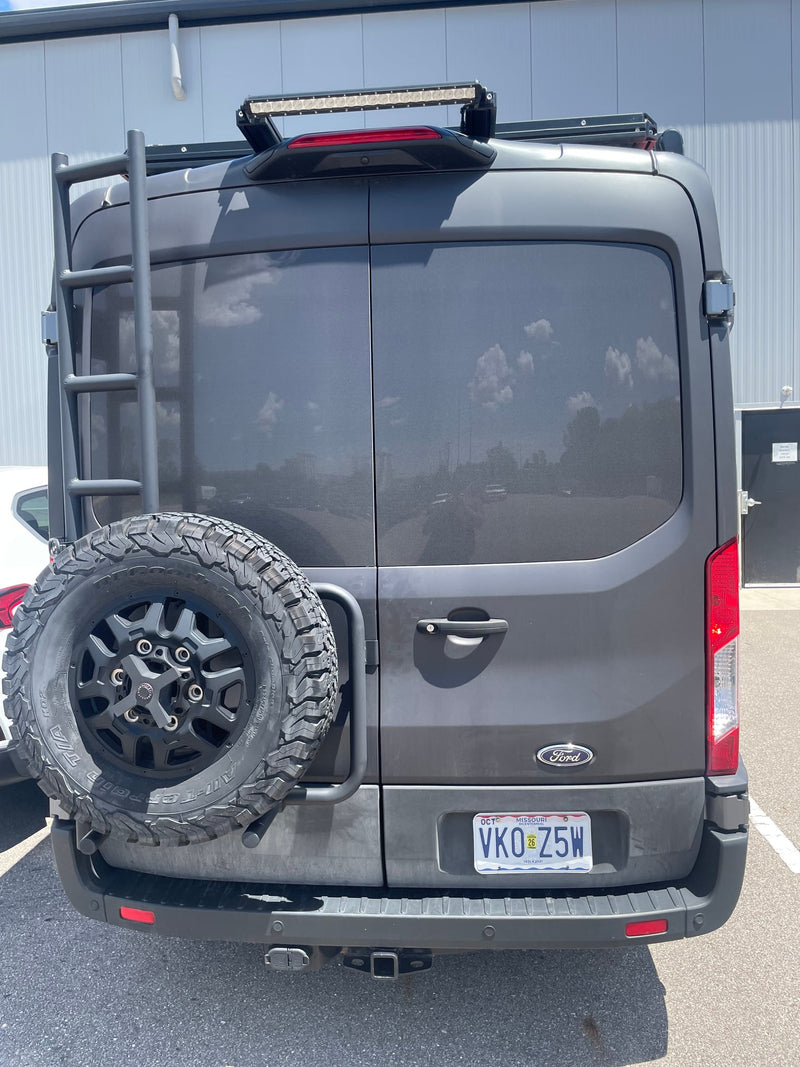  parked outdoors on asphalt.|Front view of a gray Ford van (RV rental) with a prominent roof rack — photo 3