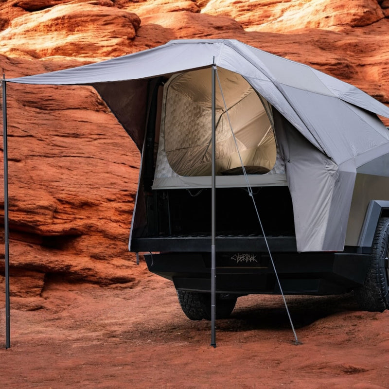 Tesla Cybertruck with a grey bed tent and extended awning for camping, parked on red desert rocks. Perfect for your next rv rental adventure! — photo 2