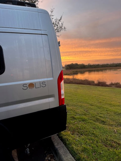 Enjoying a stunning sunset view from our RV rental. This Winnebago Solis is perfect for lakeside adventures.