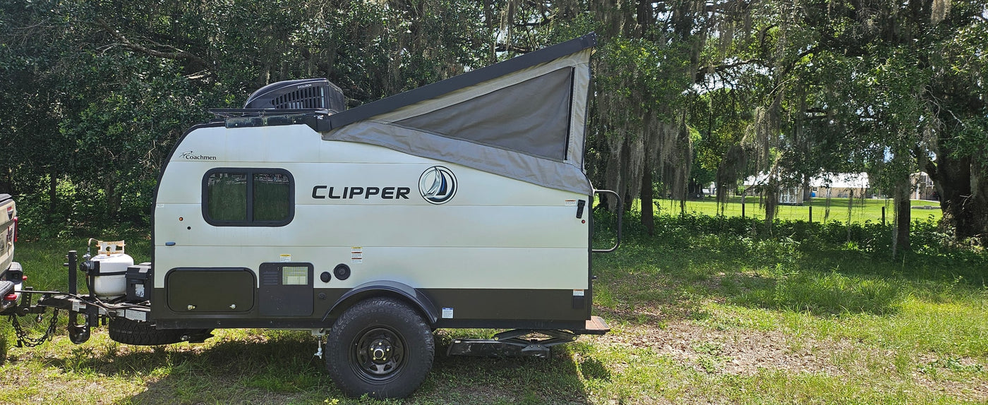 This white and black Coachmen Clipper pop-up travel trailer is ready for your next rv rental adventure in nature. — photo 4