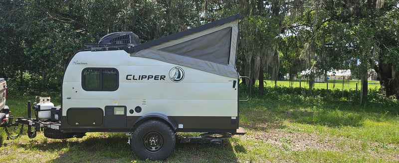 This white and black Coachmen Clipper pop-up travel trailer is ready for your next rv rental adventure in nature. — photo 4