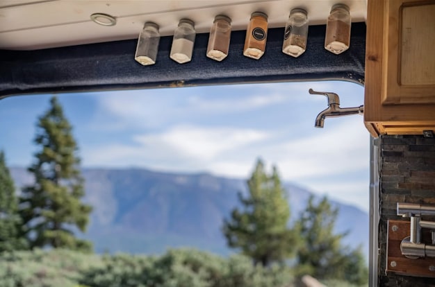 RV rental kitchen with mounted spices & faucet, offering mountain views. Perfect for van life adventures! — photo 4