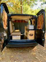 Inside an RV rental camper van conversion: custom interior with bed, fridge, and storage, ready for adventure.