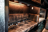 Custom RV rental interior with distressed leather seating & seatbelts. Luxury transport for your next adventure.