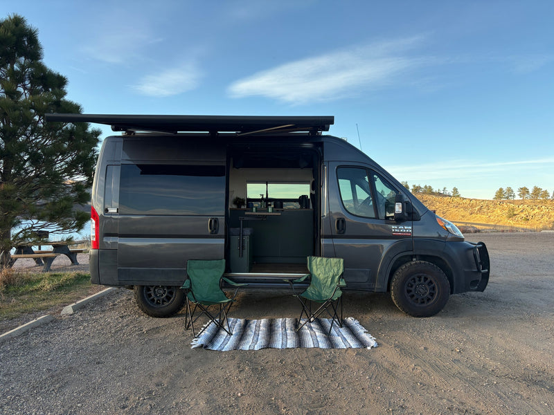 Experience van life with this RV rental! A cozy camper van parked by a lake, ready for outdoor adventure with chairs & awning. — photo 8