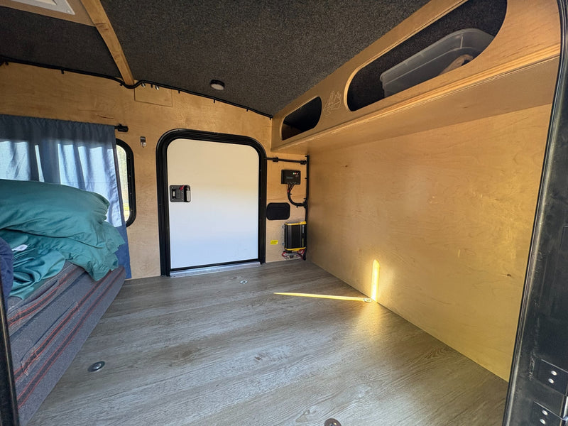  and people relaxing outdoors.|Four men enjoy snacks by a yellow Outbound Extreme camping trailer. This compact rv rental offers an outdoor kitchen for campsite adventures.|Friends gather around their yellow Outbound Extreme RV rental with an awning — photo 4