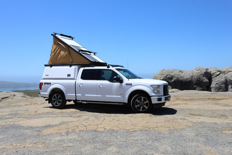 Adventure-ready RV rental: White Ford F-150 with pop-top camper, solar panels, and coastal views. Perfect for off-grid travel. — photo 1