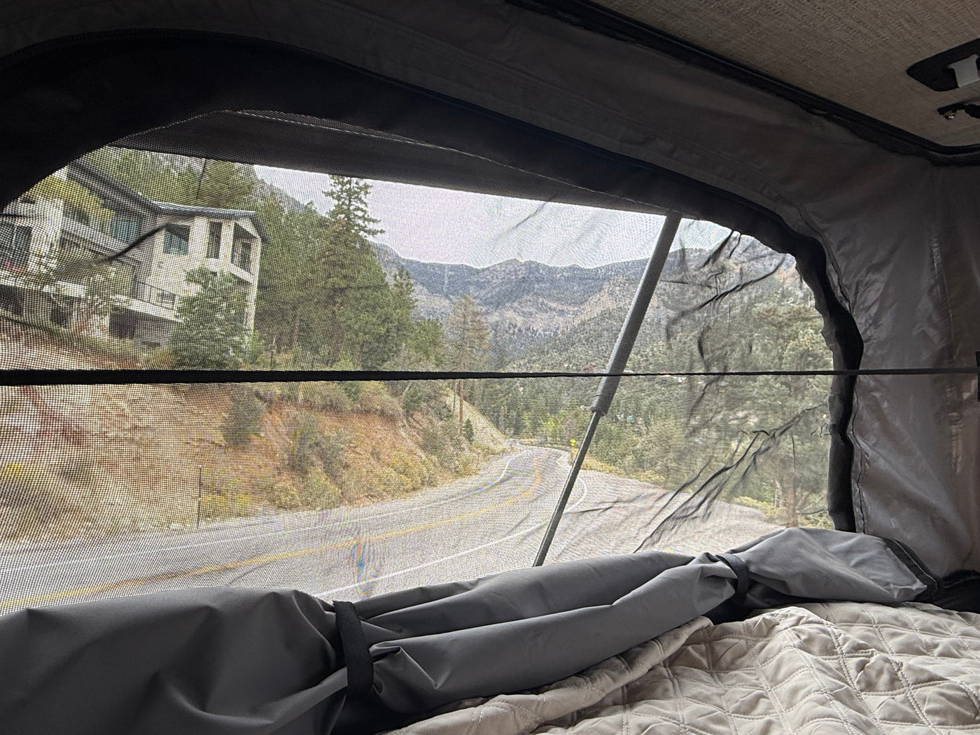 is parked with a scenic mountain view under a cloudy sky.|Cozy RV rental interior with a light wood table — photo 17