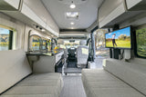 Spacious rv rental interior with kitchen, comfy seating, and TV. Perfect for road trips and relaxation.