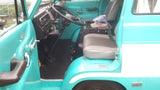 Inside a vintage turquoise "Sportsman" van, showing the dashboard and seats. Ideal for an rv rental.