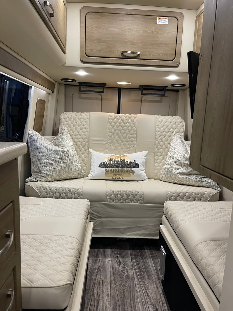 Modern & cozy RV rental interior: quilted sofa/beds, wood-look floor, and sleek overhead storage for your road trip comfort. — photo 15