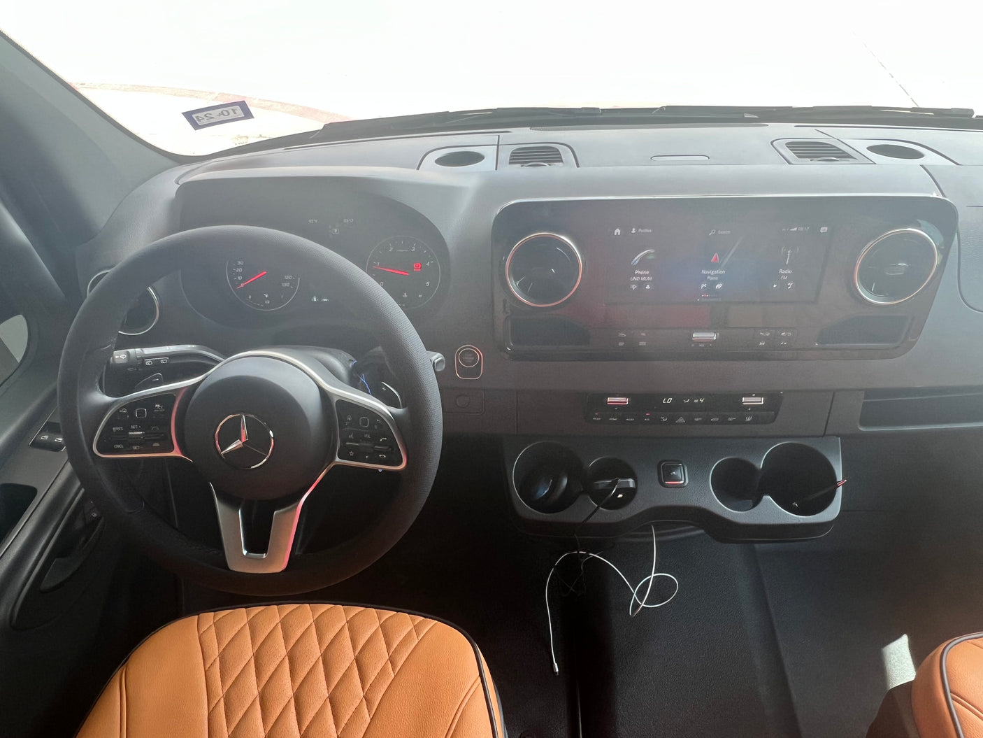 Mercedes-Benz RV rental interior: Modern dashboard, steering wheel, infotainment, and quilted seats for a comfortable journey.