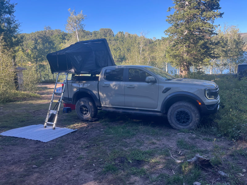 Explore off-road in a tan Ford Ranger Raptor with a rooftop tent! Great car rental for desert adventure & camping among red rocks.|A beige Ford Ranger Raptor pickup with a rooftop tent — photo 3