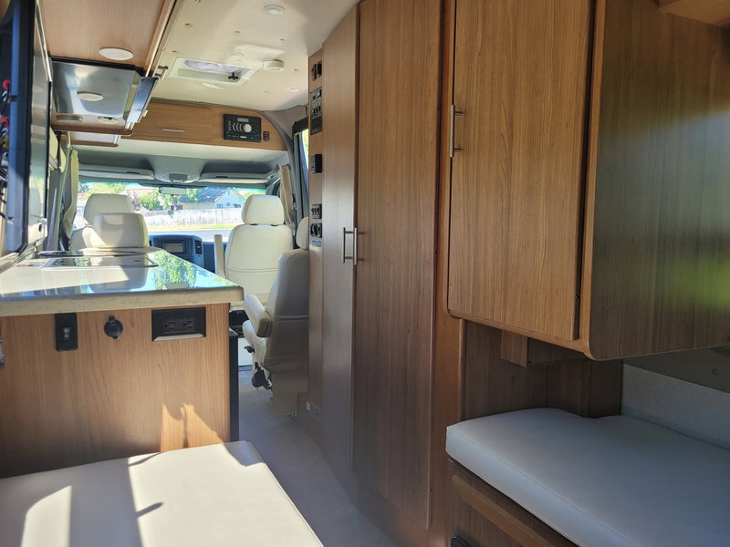  and a window view.|View inside an RV rental showing a living area with a mounted TV — photo 16