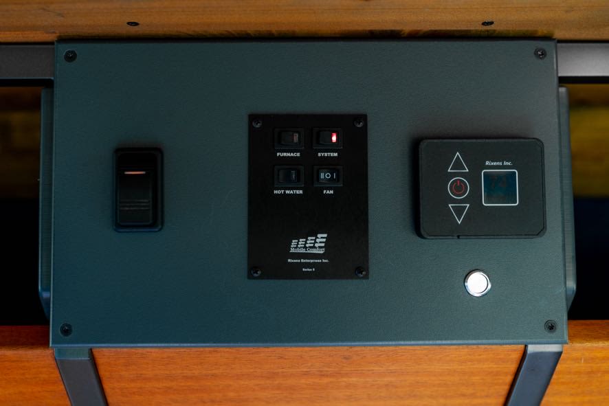 RV rental comfort panel: Toggle switch, Furnace, Hot Water, Fan switches, plus a Rixens thermostat with a red system light.