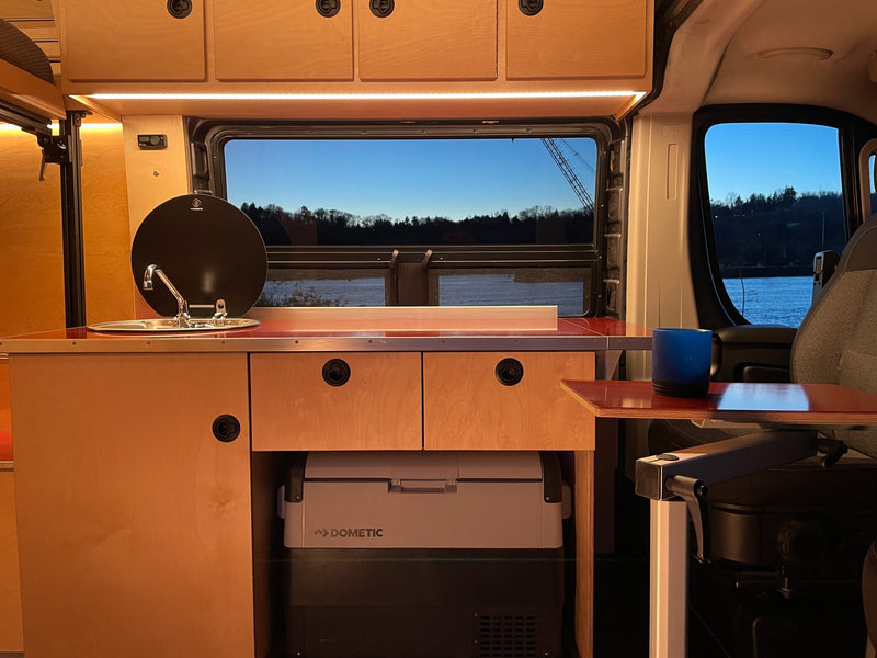 Spacious RV rental interior featuring a modern wood-paneled kitchen with sink, Dometic fridge, and scenic window views. — photo 8