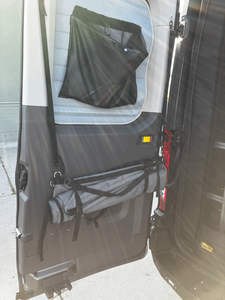 Practical RV rental features: van door storage with a mesh pocket for small items and a rolled mat for convenience.