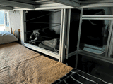 RV rental interior features modular storage, a cozy sleeping area, and power systems for comfort on the go.