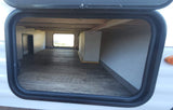 RV rental pass-through storage compartment with wood-look floor, an interior window, and a large tank labeled '3B6'.