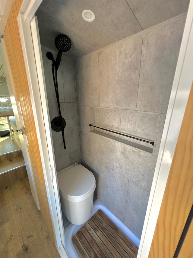  and a white countertop.|Cozy RV rental bedroom with a stunning desert landscape view from the back windows