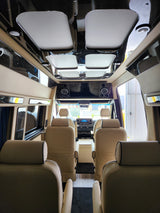 Spacious RV rental vehicle interior, featuring luxurious tan seats, a glossy ceiling, and an entertainment system.