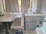 RV rental: Inside a pop-up camper featuring a dining table, bench, sink, Keurig coffee maker, and Dometic refrigerator.
