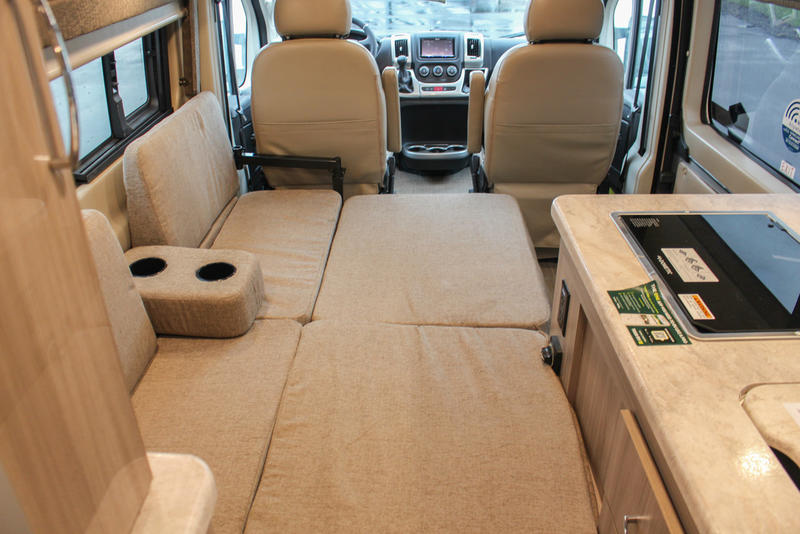 RV rental interior: front cabin, versatile seating converting to a bed, and kitchen with cooktop. Perfect for road trips. — photo 18