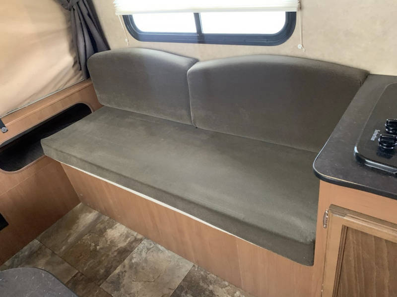 and a window with pleated blinds and tied-back curtain.|RV rental interior featuring a refrigerator — photo 6