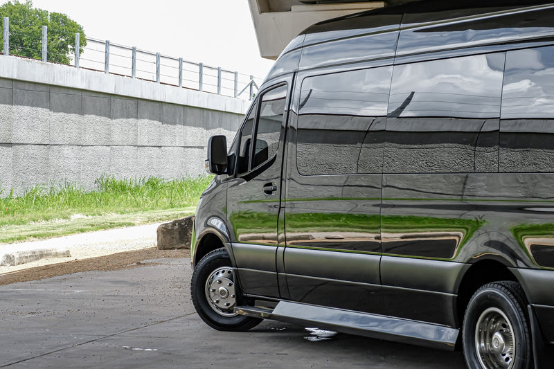 Sleek black Mercedes Sprinter van, often used for RV rental or luxury transport, parked next to a concrete wall. — photo 7