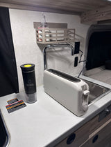 Compact rv rental kitchen: white toaster, black portable blender, and sink. Essential appliances for travel.