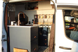 Inside this RV rental: modern van kitchen with copper faucet, stove, organized spices, and clever storage.