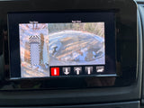 RV rental's infotainment screen displays 360-degree top and rear camera views for parking on snowy, unpaved terrain.