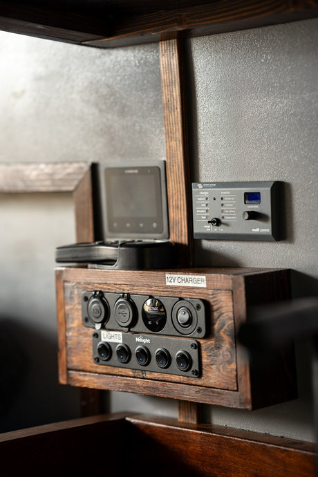 RV rental's power system: Victron inverter/charger, display, 12V/USB outlets & Nilight light switches.