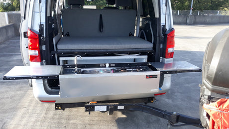 Outdoor cooking setup in an RV rental: This camper van features a slide-out kitchen with a sink and stove for convenient outdoor meals.