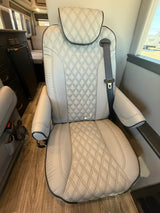 Light-colored, quilted leather passenger seat with a seatbelt in a modern RV rental interior.