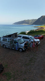 A group with an RV rental camper van and other vehicles overlooking a beautiful Maui coastal view.