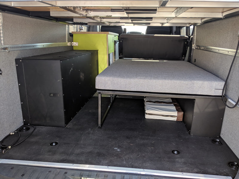RV rental: Versatile camper van interior with modular bed, storage, & bright green counter. — photo 12
