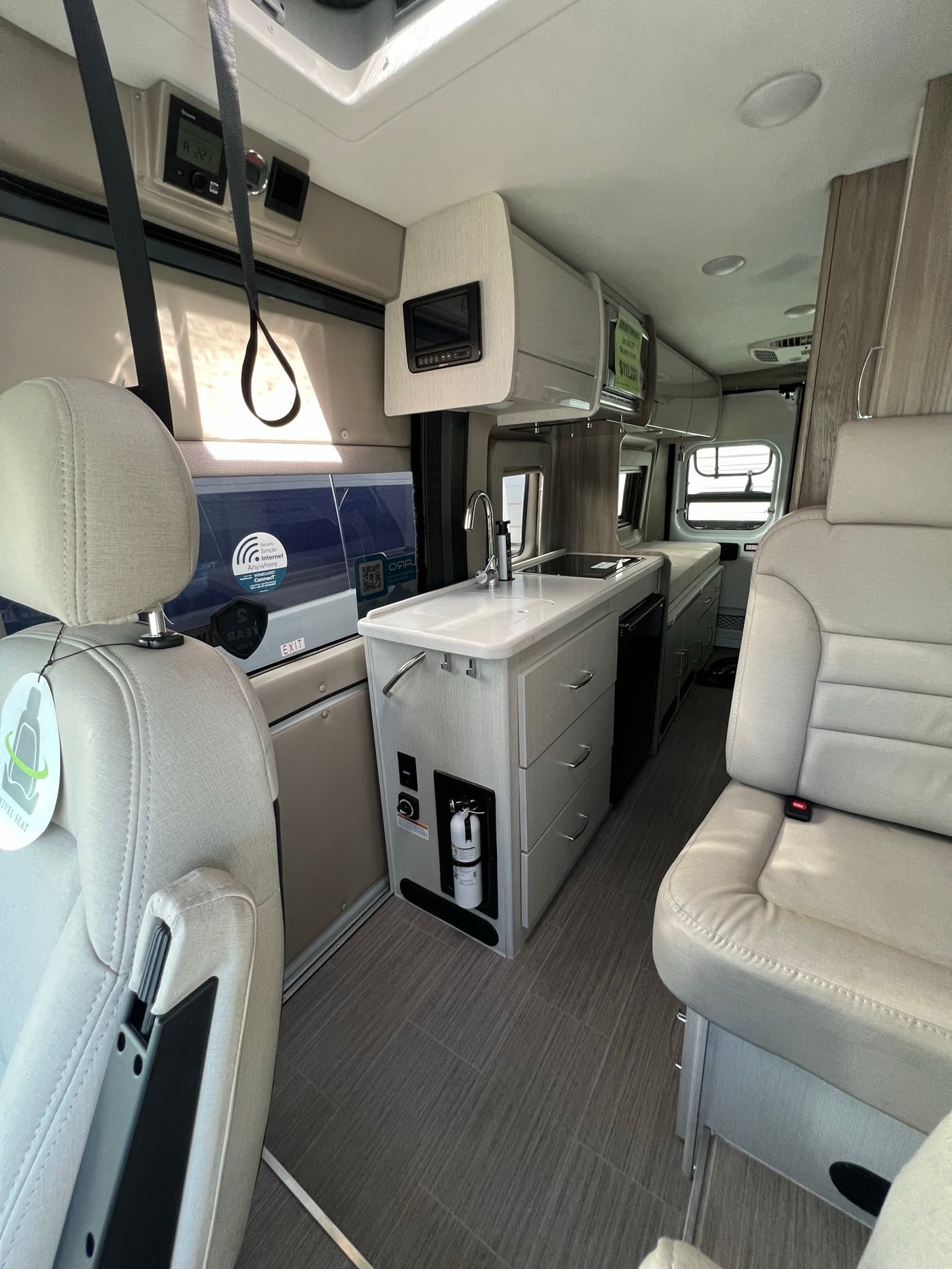  and a parked white van visible outside.|Dashboard of a Pleasure-Way RV — photo 6