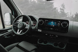 Inside a modern Mercedes-Benz van, ready for your next RV rental adventure on a rainy day. Shows the dashboard and infotainment.