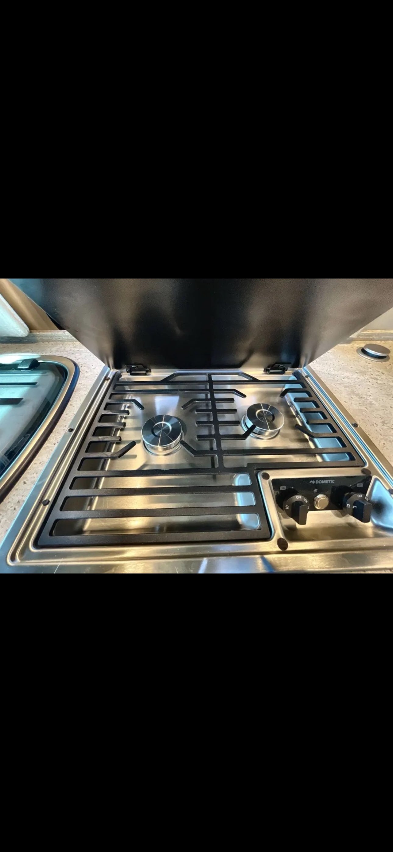 This RV rental features a stainless steel Dometic gas cooktop with two burners and controls, ready for your travel kitchen needs. — photo 6