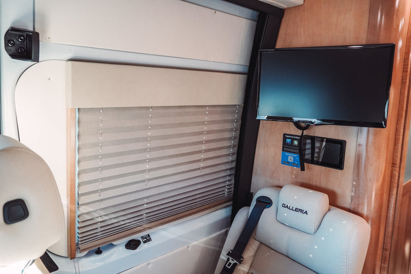 RV rental interior features: plush seat, pleated window shade, TV, and Vegatouch Eclipse control panel. — photo 11