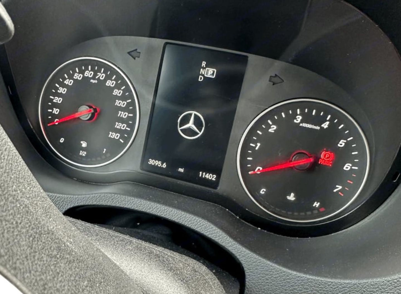RV rental vehicle dashboard displaying speedometer, tachometer, 11,402 total miles, and engaged parking brake.