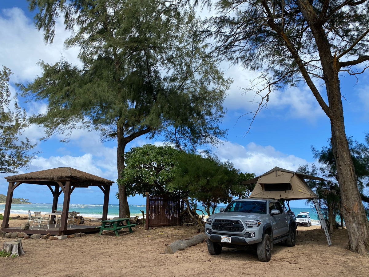 Beach camping with a truck & rooftop tent, a unique RV rental experience. Sandy site by the ocean, with a gazebo & trees. — photo 8