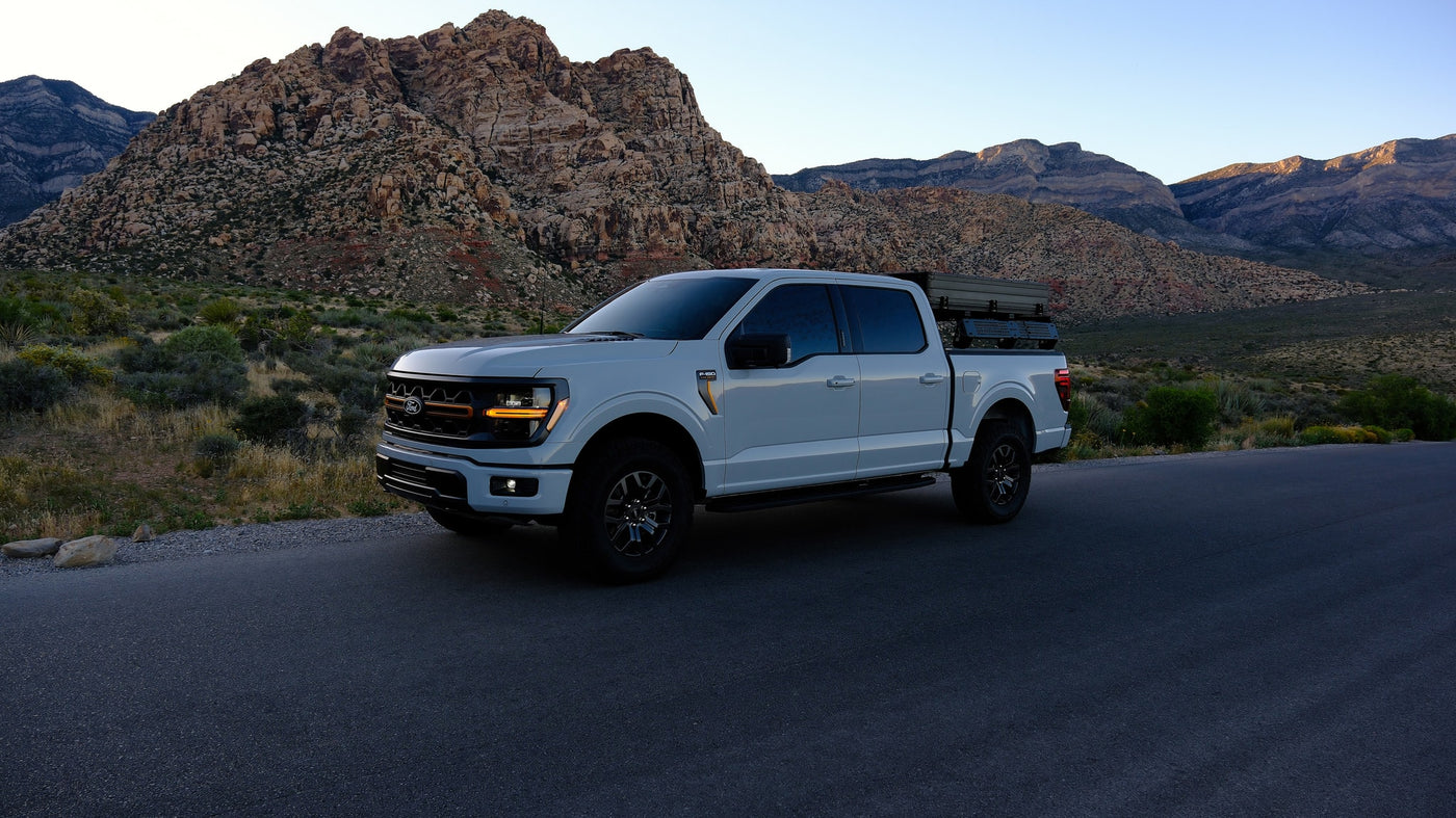 White Ford F-150 with rooftop tent for outdoor adventures, a unique alternative to an RV rental, set against desert mountains. — photo 20