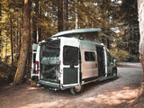 Explore nature with this white pop-top rv rental van parked in a serene forest, showing its open doors and ready for your next adventure.