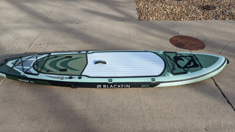This green Blackfin Model XL inflatable paddleboard on concrete is ready for RV rental travel and water adventures.