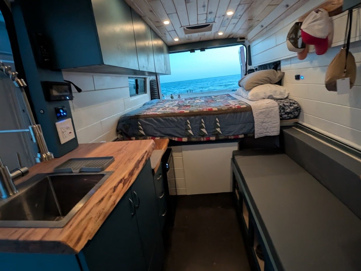  overlooking a sandy beach and ocean under a blue sky.|Cozy RV rental interior: kitchen — photo 2
