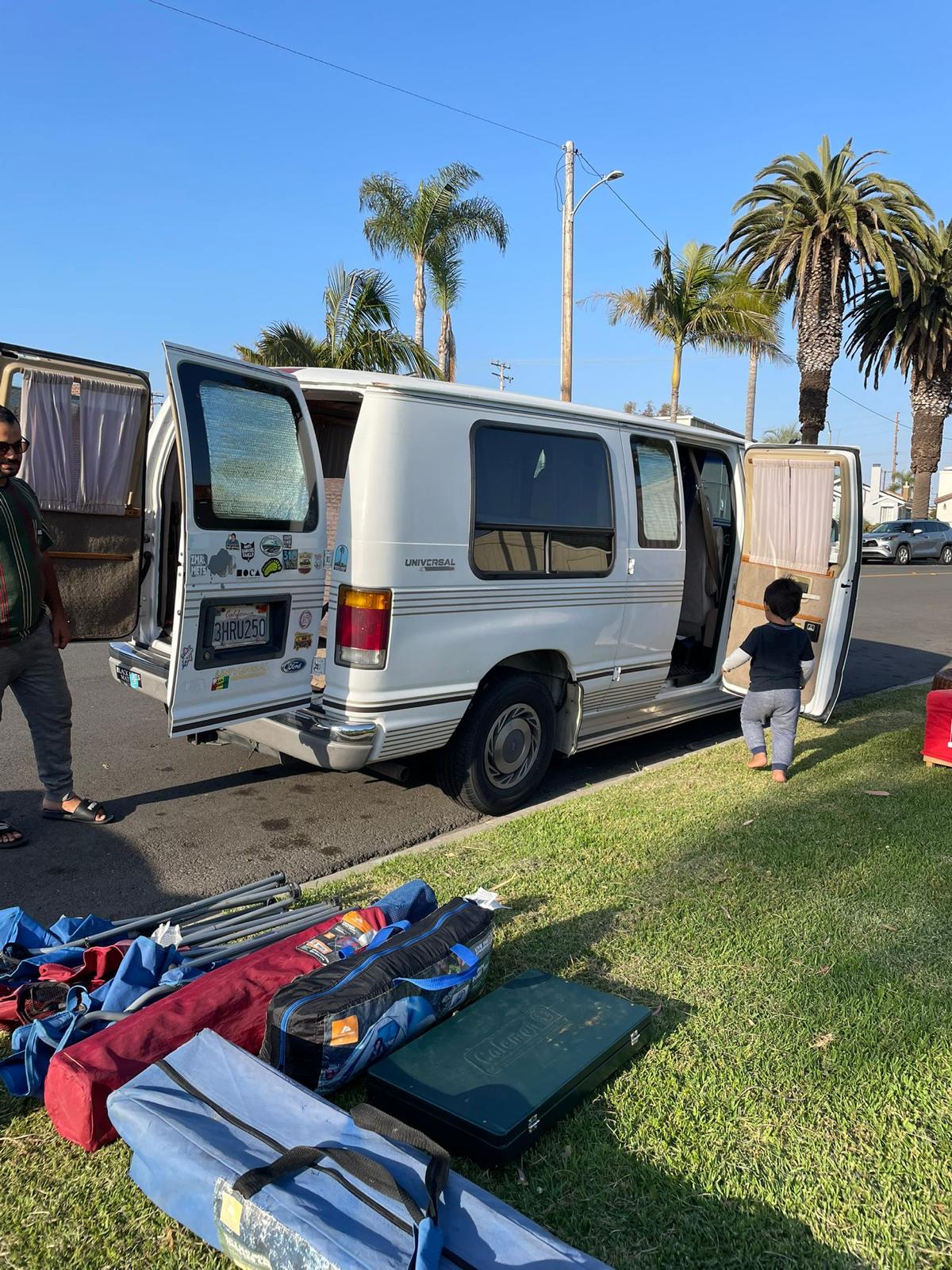Unloading an RV rental: A white conversion van with open doors